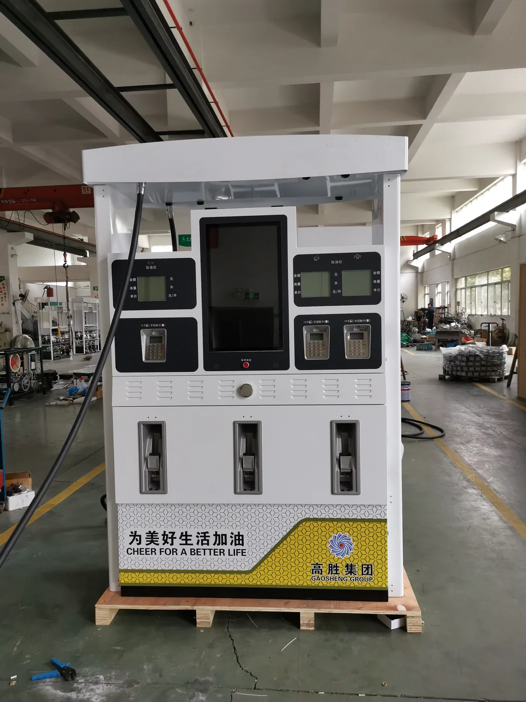DT-M multimedia dispenser in the workshop, white cabinet with vertical LED screen and three nozzle holsters, customer branding
