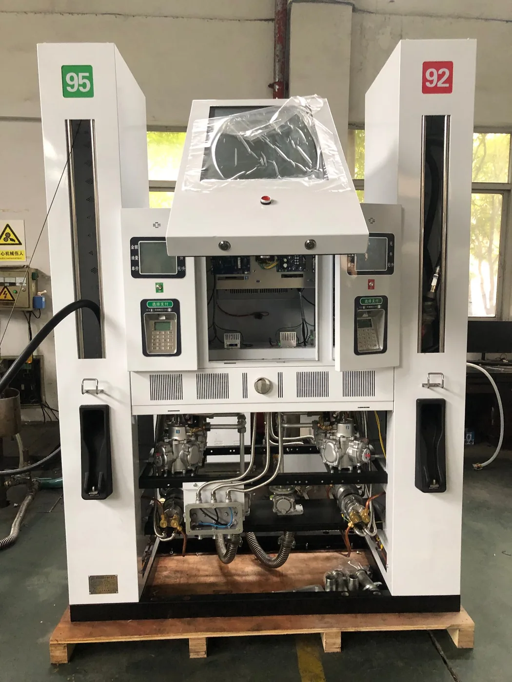 DT-M multimedia dispenser with top cover open, two nozzles (95 and 92 labels), LED screen visible inside, hydraulic pump system exposed